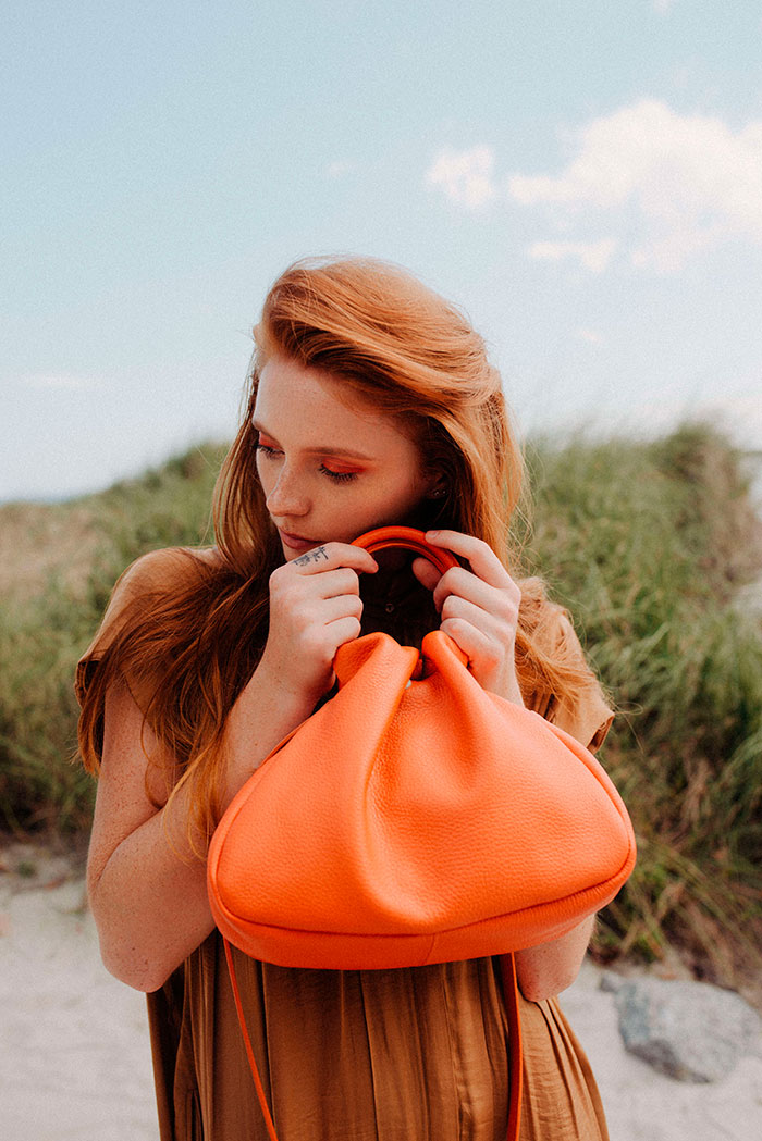 mujer con bolso mediano color naranja