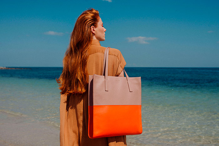 mujer frente al mar con tote bicolor